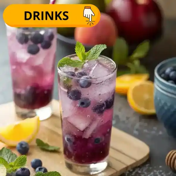 A refreshing drink in a glass filled with ice, blueberries
